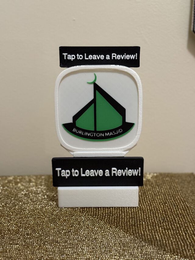A white TapCraft Stand Pro with the green Burlington Masjid mark and 'Tap to Leave a Review!' signs top and bottom.